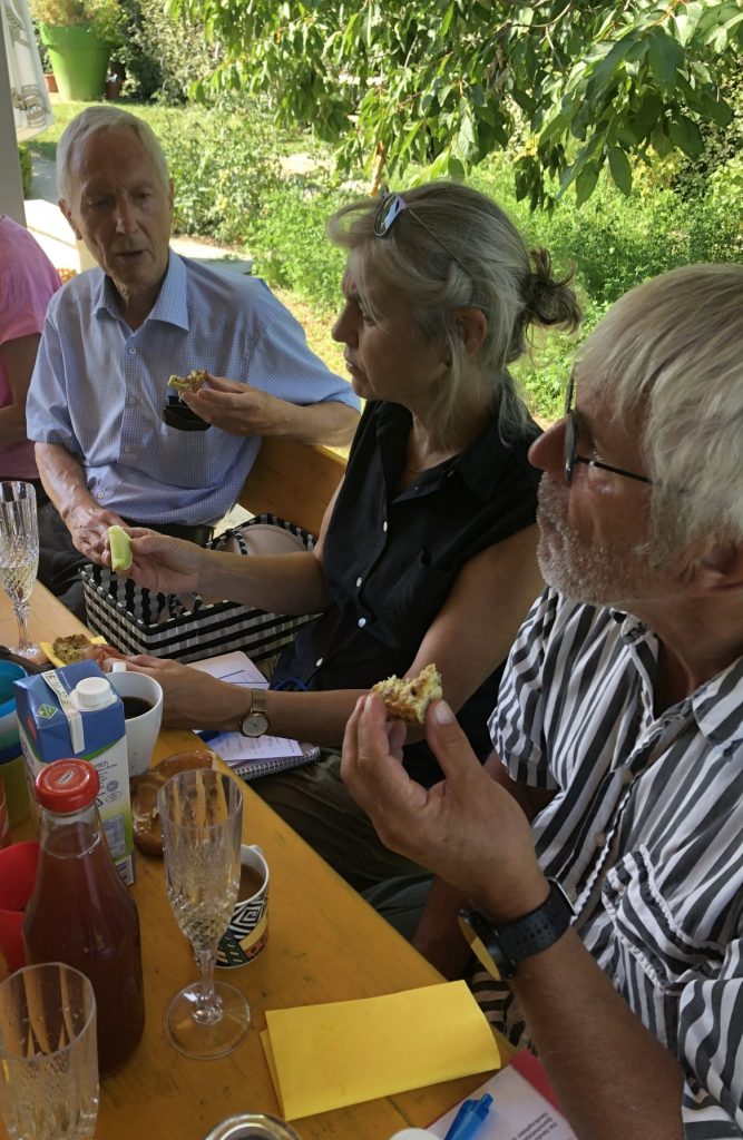 Arbeitskreis-Teilnehmende beim Essen im Garten
