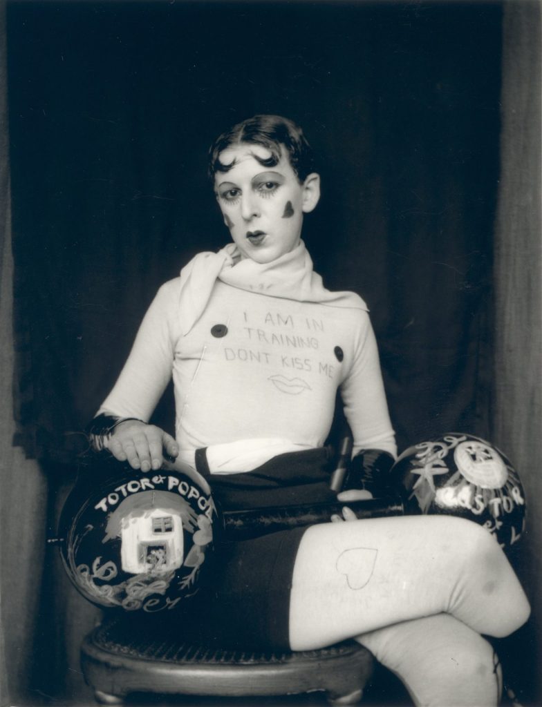 Portrait of Claude Cahun wearing a shirt that says "I Am in Training Don't Kiss Me". 1927,
